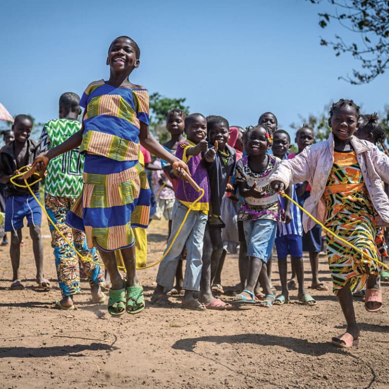 Barn fra den Sentral Afrikanske Republikk hopper tau. De har på seg fargerike klær. Foto: Mickael Franci