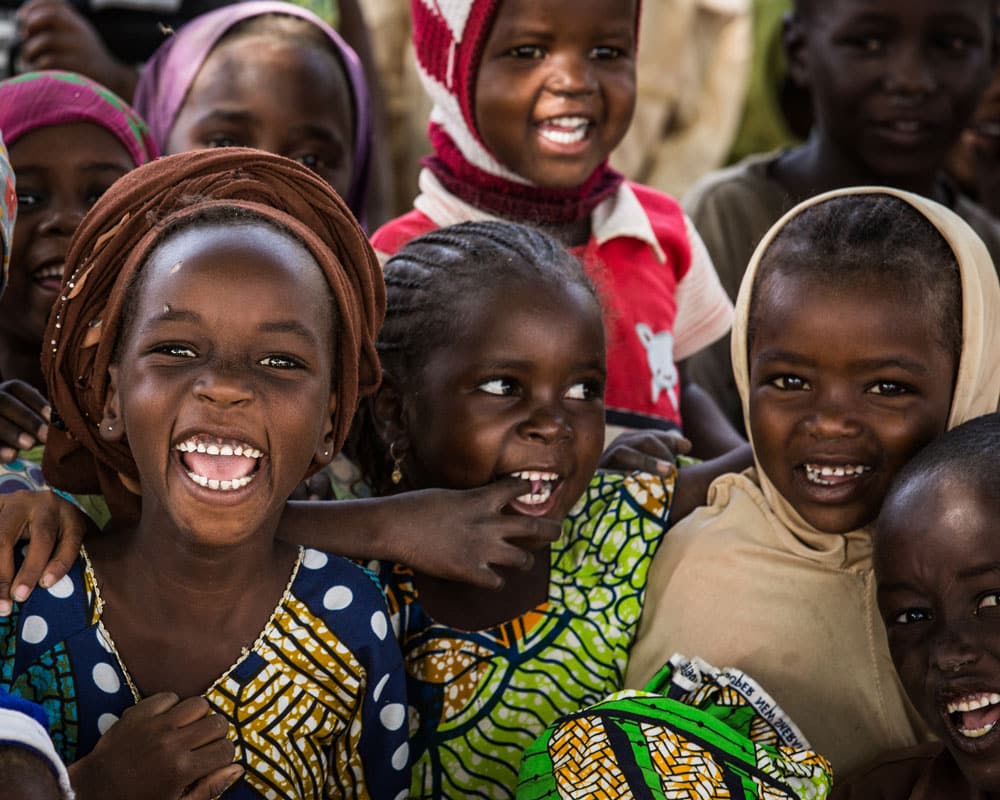 Glade jenter fra Niger i fargerike klær. Foto: Vincent Tremeau