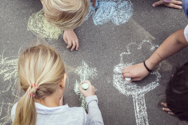 Barn som tegner med kritt i gaten