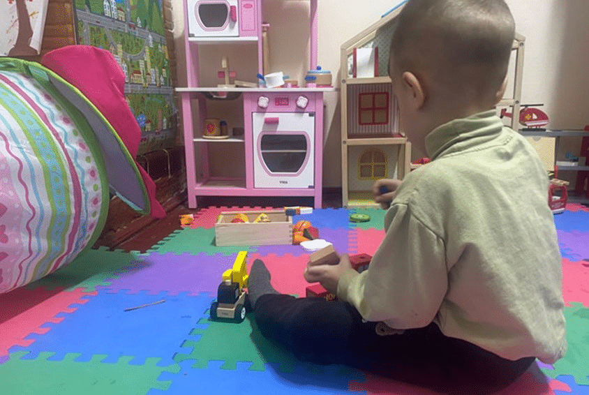 Et trygt sted for lek. En gutt sitter på gulvet med leker foran seg. Foto: Sigurd Skjefstad