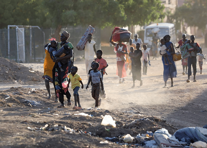 Sudan: Familier med barn flykter fra kampene. De går på en støvet vei, Foto: AFP