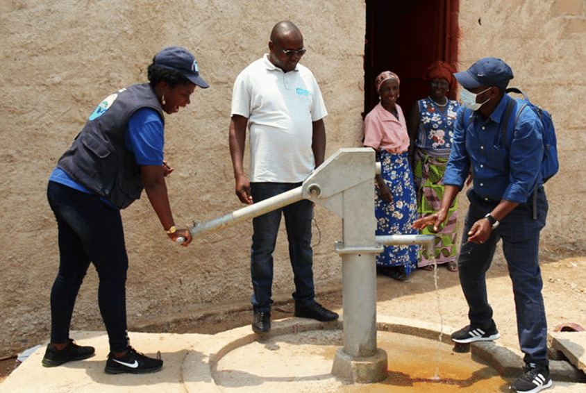 Medarbeidere fra SOS-barnebyer tester vannpumpen. Foto: SOS-barnebyer