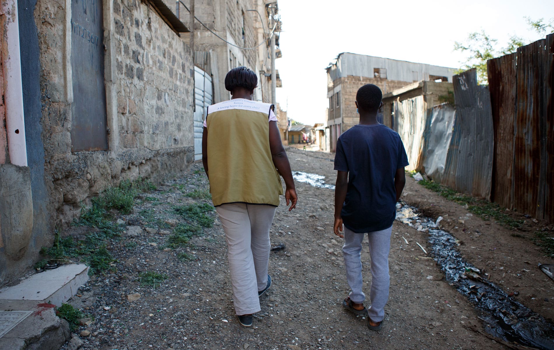 Wairegi og SOS-barnebyers sosialarbeider går ut i gata og har en samtale. Foto: Jakob Fuhr