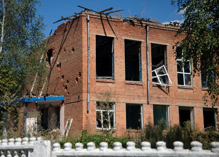 Ukraina: En skolebygning i rød murstein er rammet av raketter, alle vinduene er knust. Foto Katerina Ilievska