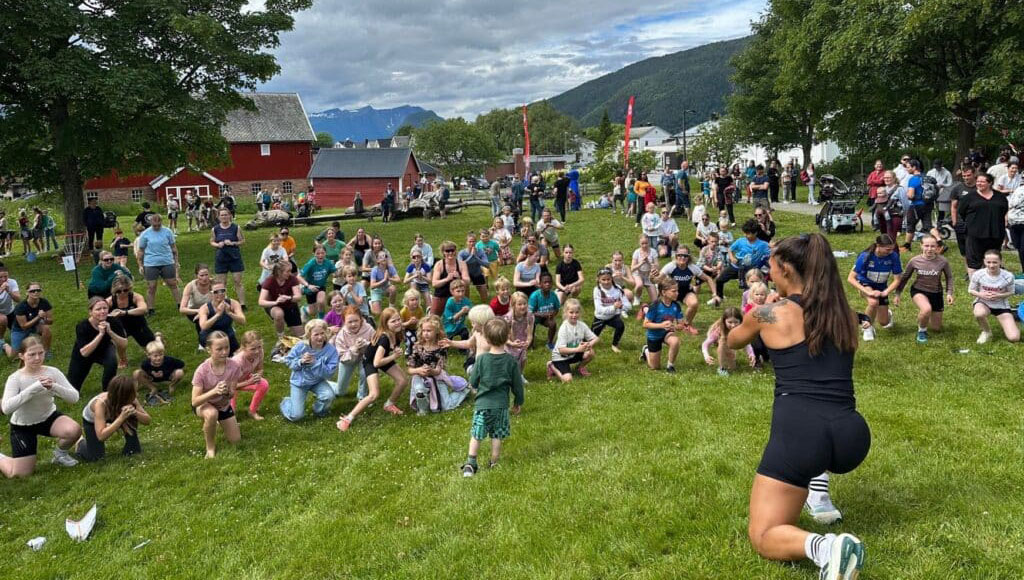 Lokalsamfunnet i Rauma engasjerte seg for Gaza. Her er det Funkygine som leder ei yogaøkt der både store og små deltar. De står på ei stor gressslette, i bakgrunnnen er det bondegårder. Foto   Lene Bonesmo Solberg