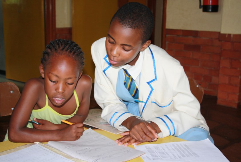 Barn i barnebyen gjør leksene sine etter skolen. Foto: Janie Dufty
